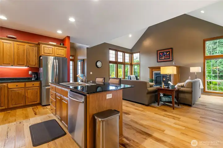 The Hickory wood floors is a real stand out in this photo taken from the dining area. The wall of windows in the distance really captures how much natural light comes into the living space!