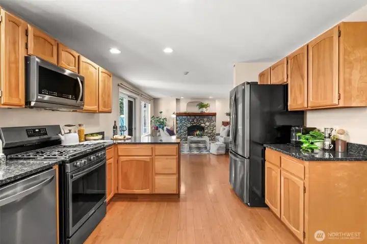 Kitchen flows right in to a cozy space with custom river rock fireplace and mantel