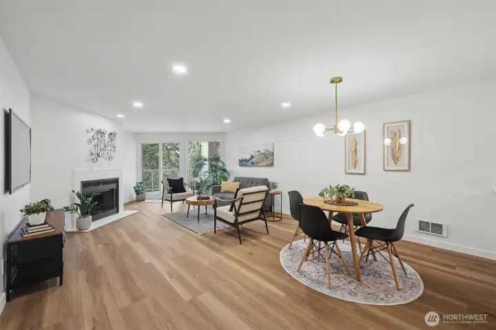 Dining and living area with fireplace and deck access