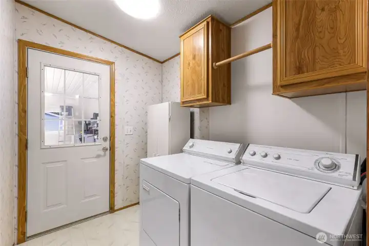 Laundry room with upper cabinetry and  convenient access near the back entry