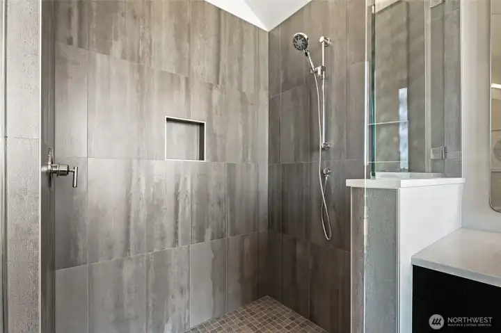 Photos of model home 9752 with similar finishes & floor plan. Sleek tiled shower with built-in niche and rain-style wand—every morning feels like a fresh start.