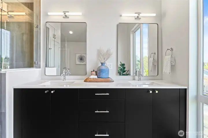 Photos of model home 9752 with similar finishes & floor plan. Sleek dual-sink vanity, custom mirrors, and designer lighting add function and flair to the primary suite experience.