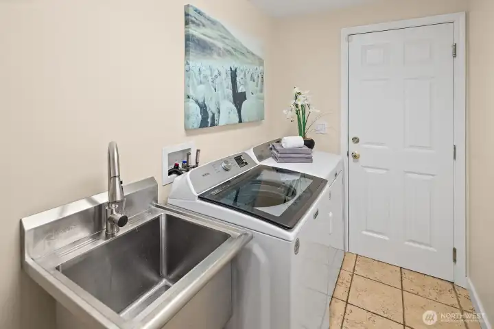 Laundry room with '22 and '25 dryer and washer; entrance to the garage. Laundry room with '22 and '25 dryer and washer; entrance to the garage.