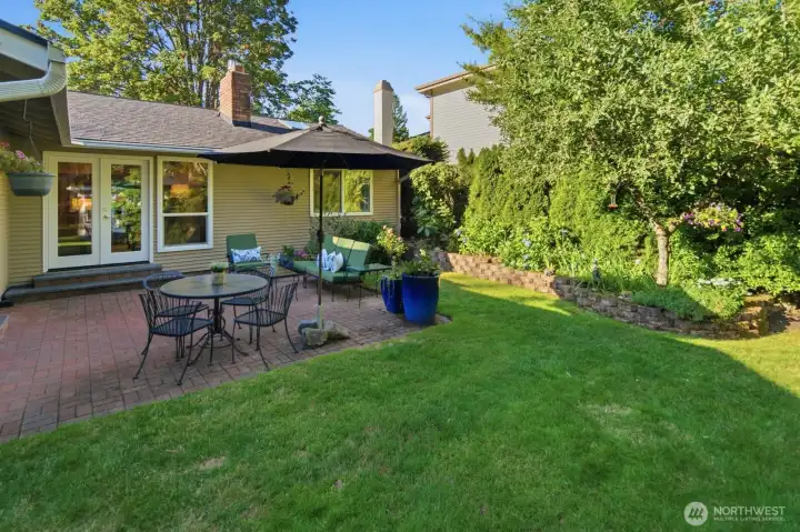 Fruit trees and raised garden beds adorn the backyard next to the patio. Fruit trees and raised garden beds adorn the backyard next to the patio.