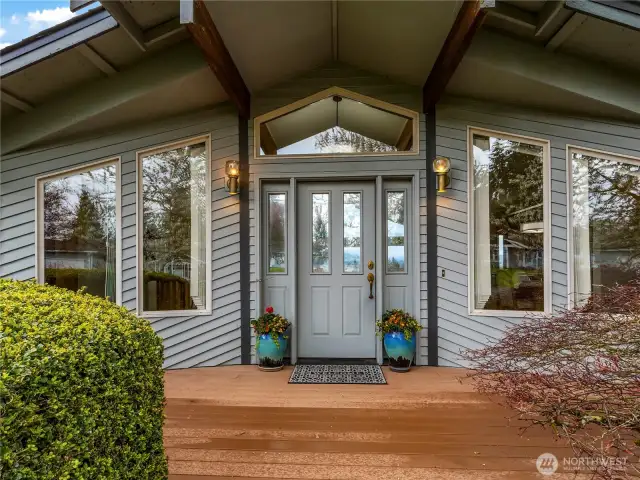 The pulled roof line provides cover of the front porch. Large windows adorns the front of the home.