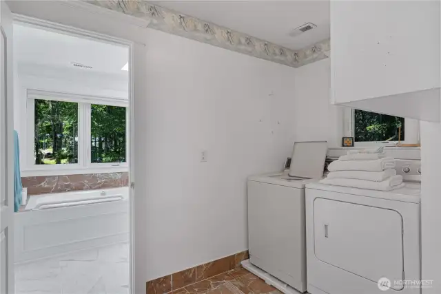 Laundry room with bathroom beyond.