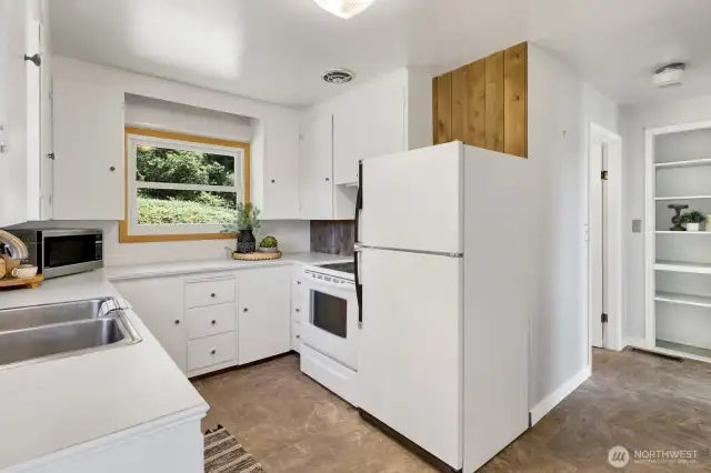 Bright and cheery kitchen has maintained its charm with many of the original cabinets
