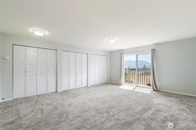 upstairs bedroom with 3 closets and door out to the balcony