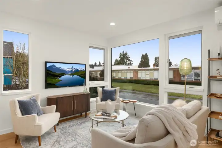 The living room radiates comfort and livability, with wide-plank flooring, modern lighting, and space for both entertaining and relaxing.