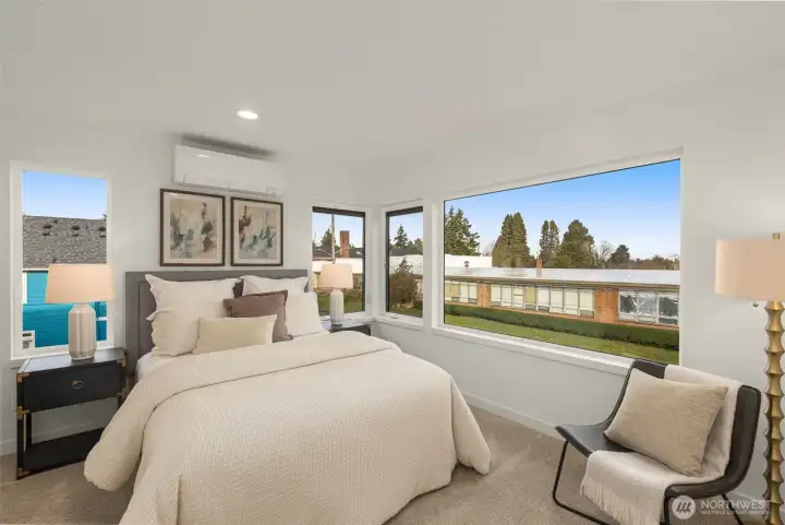 An airy, light-filled bedroom offers a calm retreat, with windows framing neighborhood views and space for restful nights.