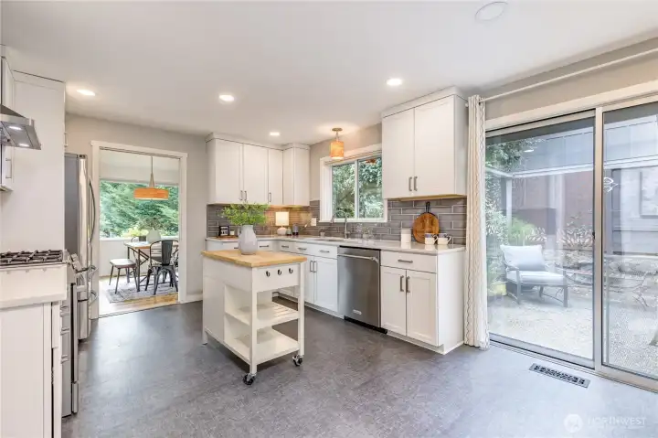 Bright white cabinetry and a stylish tiled backsplash create a timeless, inviting setting for this well-appointed kitchen.