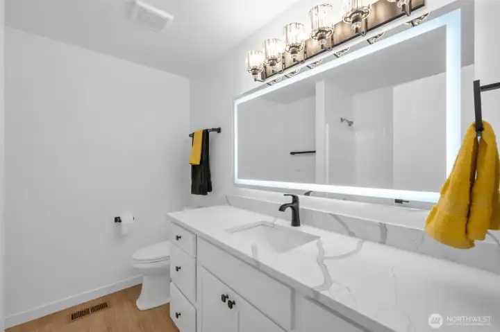 The primary bathroom has lots of counterspace and huge light mirror. Getting ready in the morning will be a breeze.