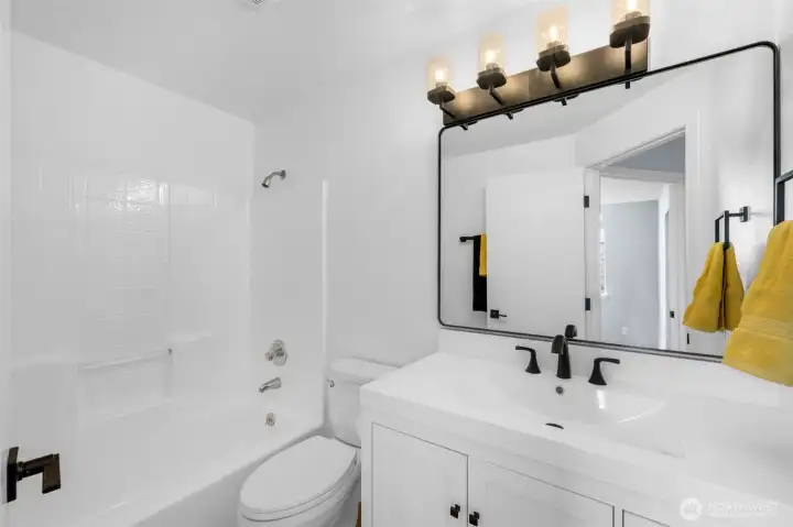 Full bath off the hallway with new flooring, vanity, lighting and fixtures.