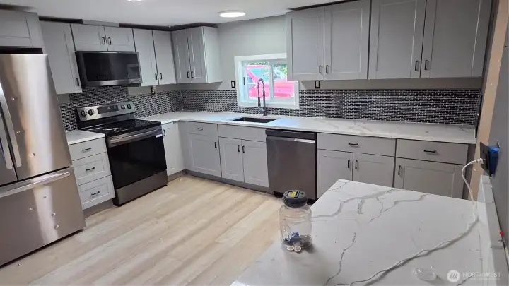 The beautifully renovated kitchen is enhanced with quartz countertops and brand-new cabinetry, blending style and functionality.