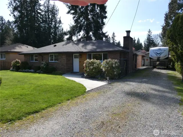 Warm inviting front of home with a deep driveway for RV parking