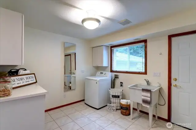 The main level laundry room is huge and includes tile floors, a folding counter, utility sink (perfect for washing your pets or projects) and plenty of storage