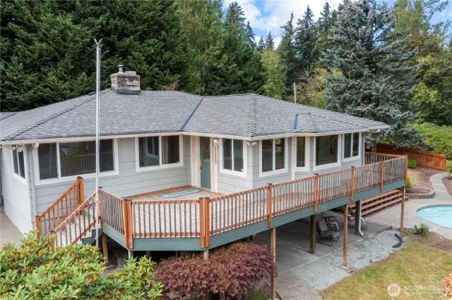 The front porch area and large wrap-around deck leads to the pool and added deck area.