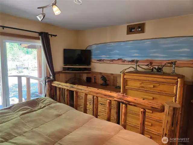 Stampeding wild horses mural on the wall of the primary bedroom.