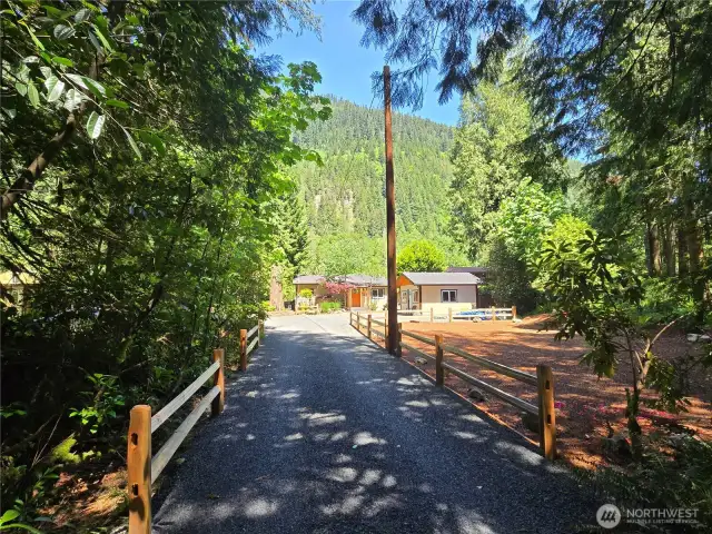 The driveway is framed by a beautiful split-rail approach.