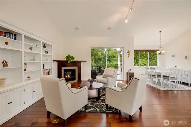 The elegant living room, anchored by a striking fireplace and walls of windows, frames tranquil views while offering an inviting backdrop for everyday living and stylish entertaining.