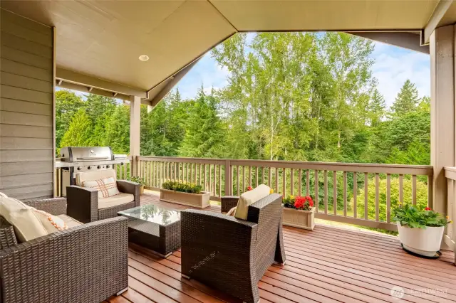 Large sliding glass doors open up to the covered back deck w/backyard access, seamlessly connecting indoor and outdoor living while enjoying the serene views of lush greenery.