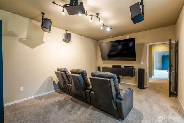 Down the hall, discover an additional bonus room, currently configured as a home theater and office. The home theater setup—including chairs, speakers, and TV—is negotiable with the sale, offering a turnkey entertainment option.
