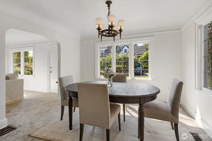 Formal dining room with vintage light fixture, leading glass windows, coved ceilings and picture rail.