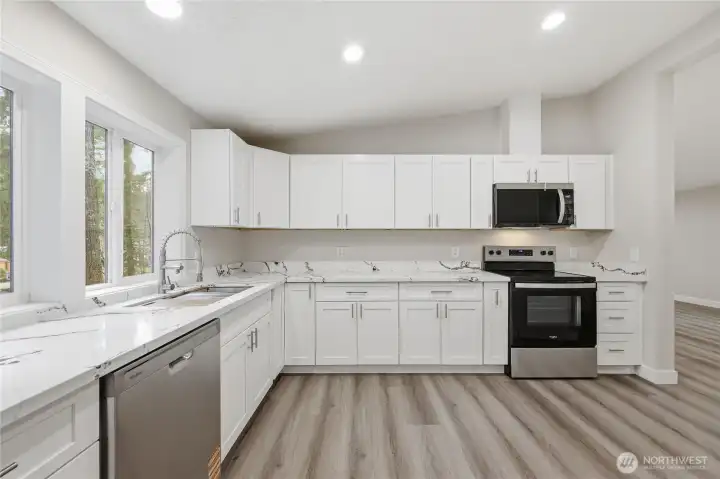 Huge ktichen with stainless steel appliances and brand new white cabinets