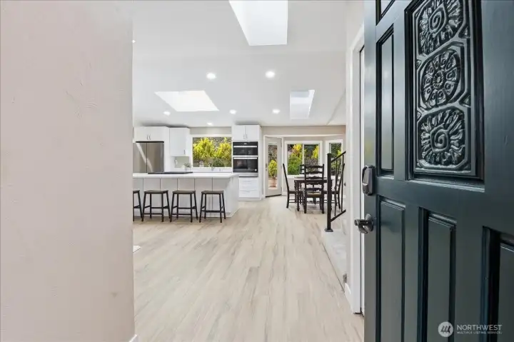 Bright and welcoming entry opens to airy living spaces, skylights, and a beautifully updated kitchen.