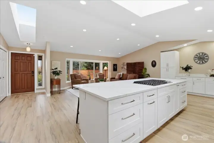 Expansive kitchen and living area with quartz island, skylights, and seamless flow throughout.