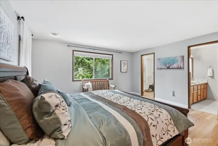 Primary suite with easy access to the ensuite bath, walk-in closet, and peaceful backyard outlooks.