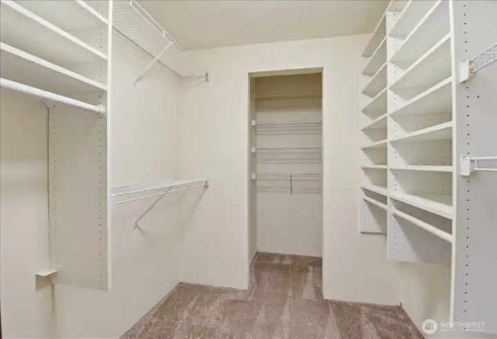 Spacious walk-in closet with built-in shelving, hanging space, and room for easy organization.