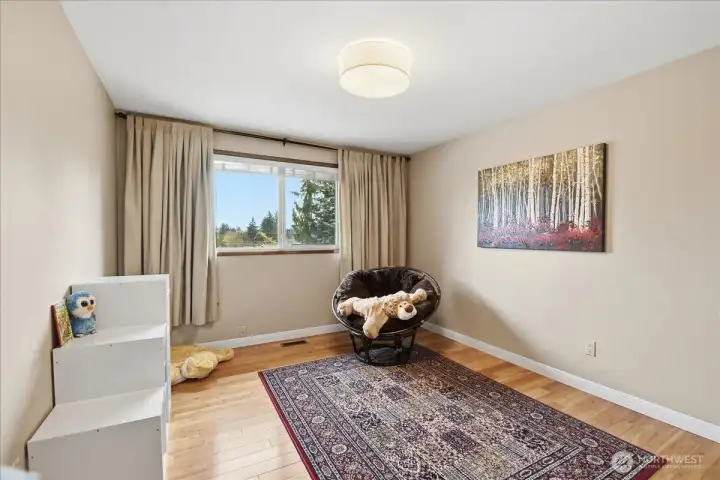 Light-filled guest bedroom with hardwood floors and versatile space to fit your needs.