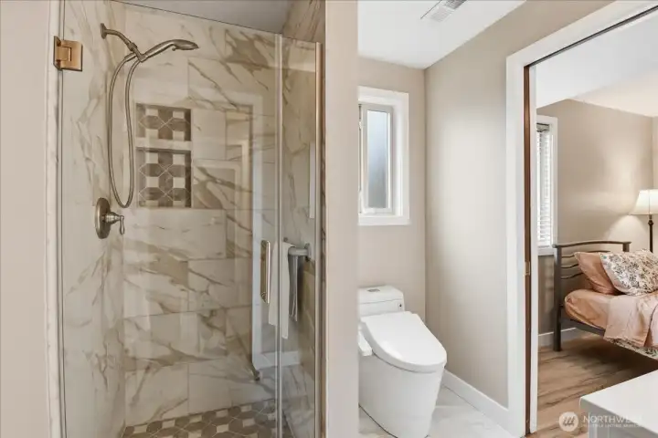 Stylish 3/4 bath with glass-enclosed tile shower and easy access from the adjacent fourth bedroom.
