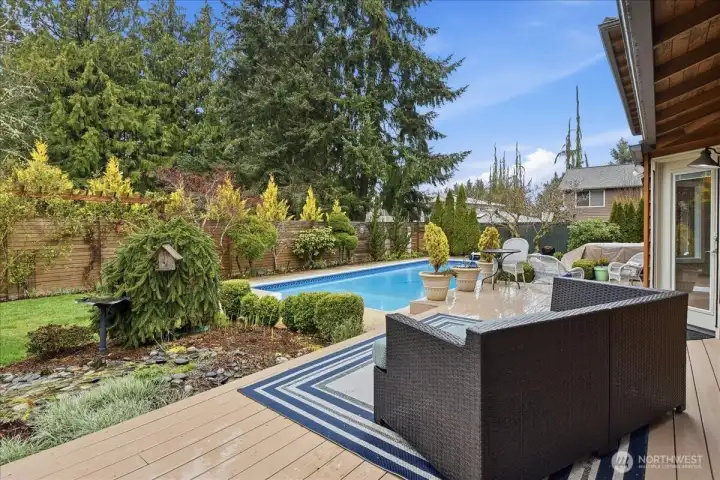 Private backyard retreat with composite deck, in-ground pool, hot tub, patio, and beautifully landscaped surroundings.