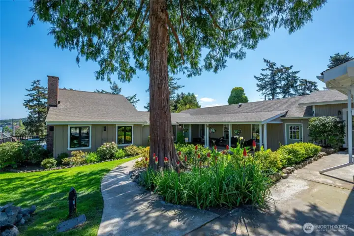 Beautifully landscaped gardens surround this charming home located on a corner lot.