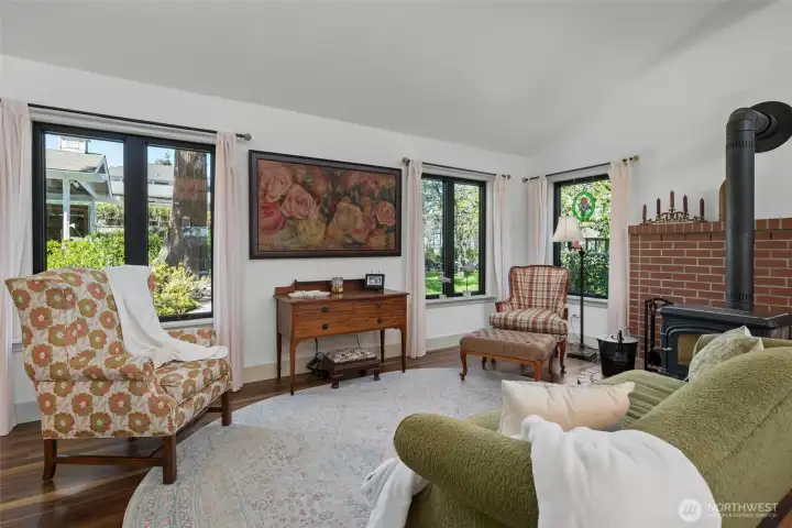 Large windows and the cozy wood burning fireplace create a delightful living space. Custom Art TV an additional feature.