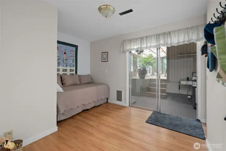 Bedroom three, with sliders leading to the enclosed breezeway and sunroom.