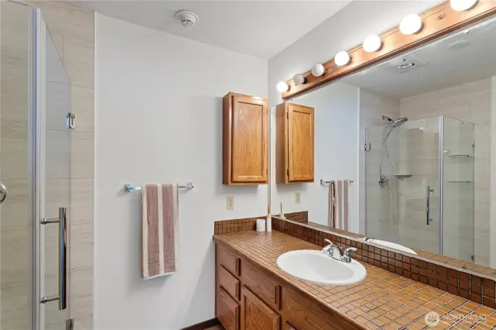 The primary bathroom with a walk-in shower, new toilet and new basin with new faucet.