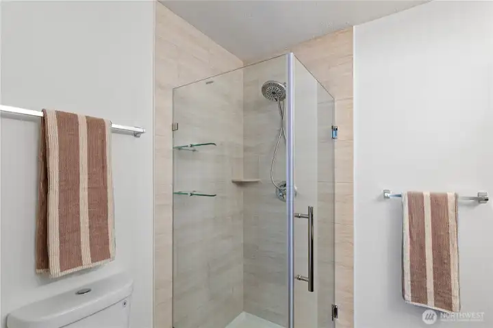 Newly tiled walk-in shower with new glass surround, shower tray and fixtures.