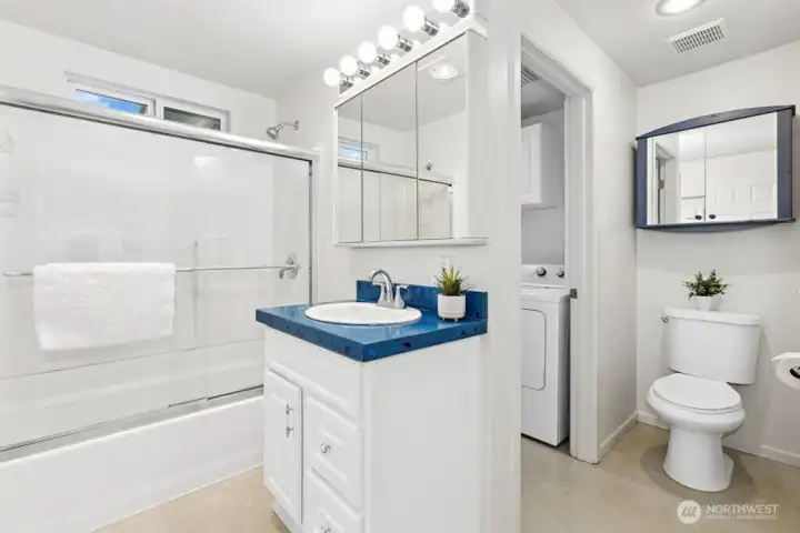 Light and bright main bathroom with tub/shower is also adjoining the laundry room