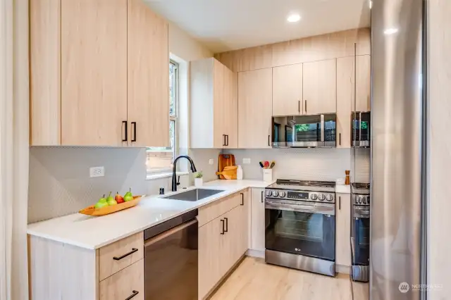 The modern kitchen is fully equipped with Quartz countertops and LG appliances