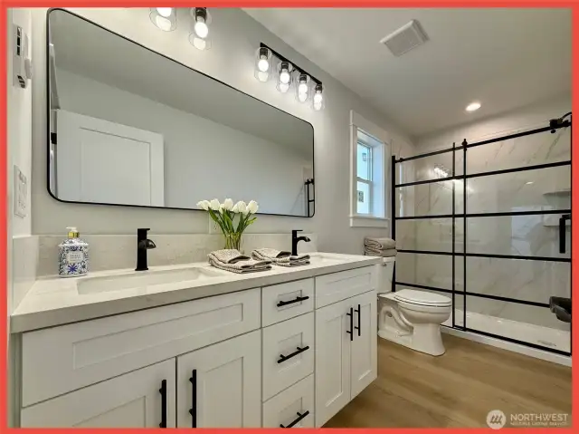 Double vanity and beautiful glass door grace the primary bathroom