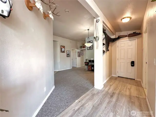 Hallway view to open office space, utility room & attached garage exit