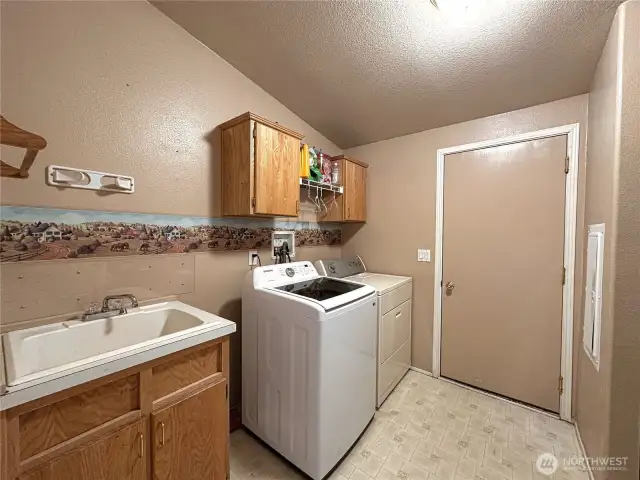 Large utility room with entrance to attached garage