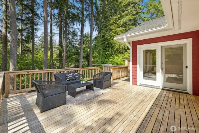 The large deck on the back of the home has great space for lounging and dining, plus a built-in hot tub adjacent to the primary bedroom.