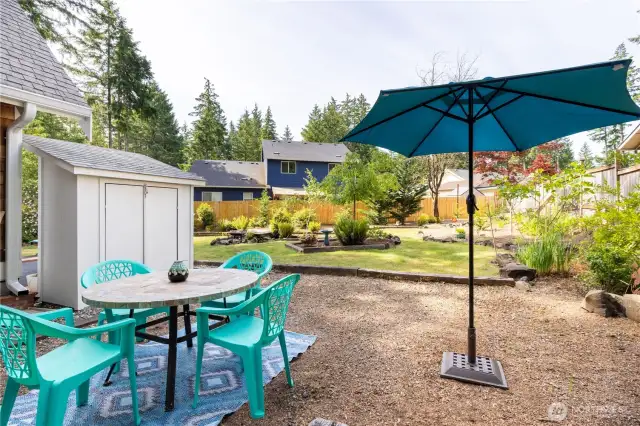 Side of home with BBQ and table