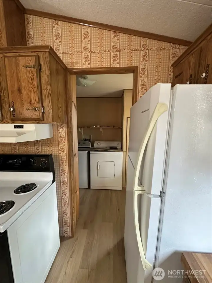 Laundry room beyond the kitchen with back deck entrance