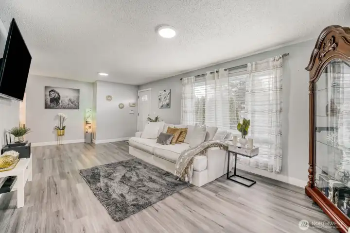 Spacious corner living area with large windows and energy-efficient mini-split heating and cooling.