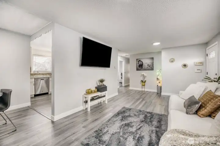 Wide view of open living space showcasing updated flooring and move-in ready interior design.